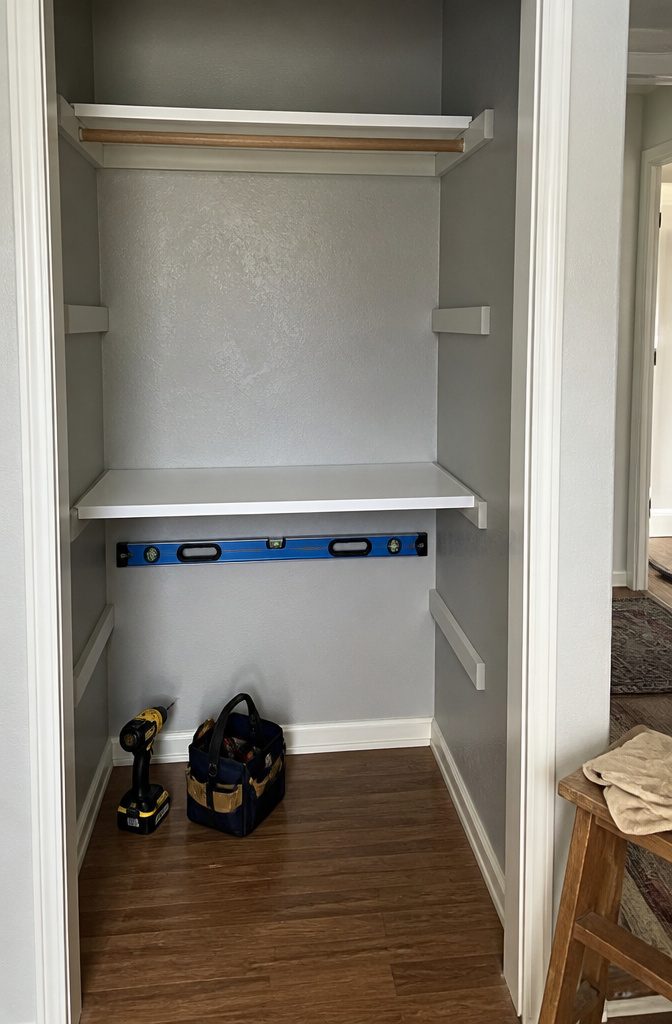 A newly installed shelf being positioned on support brackets.