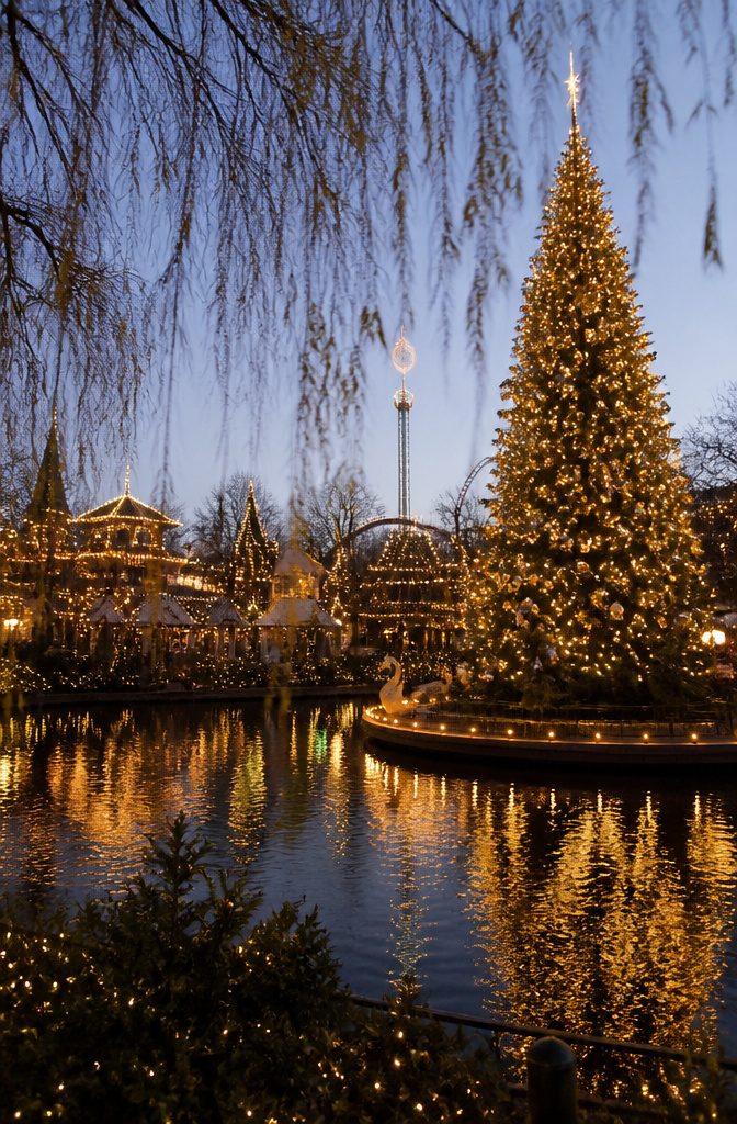 Where to Spend the Holidays: 14 Destinations for 2026 10 Tivoli Gardens decorated for the holidays with lights and a Christmas tree.