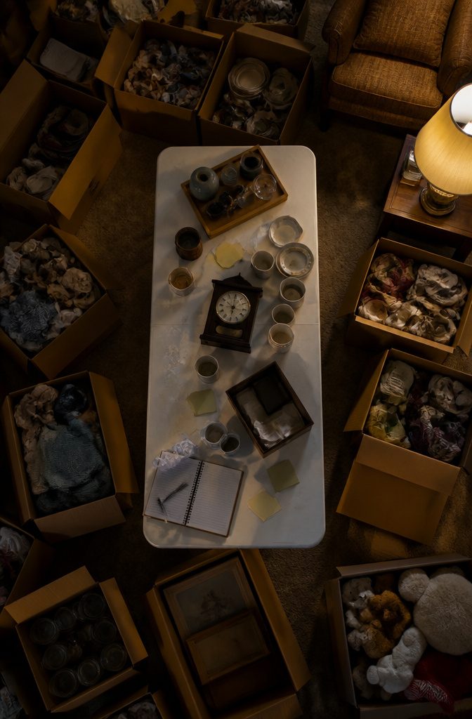 A living room covered with boxes and items, indicating preparation for a garage sale.